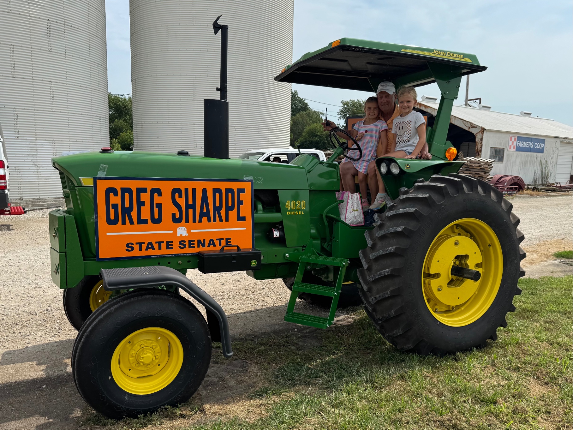 Greg Sharpe with his grandchildren on a John Deere tractor at a Northeast Missouri farm cooperative